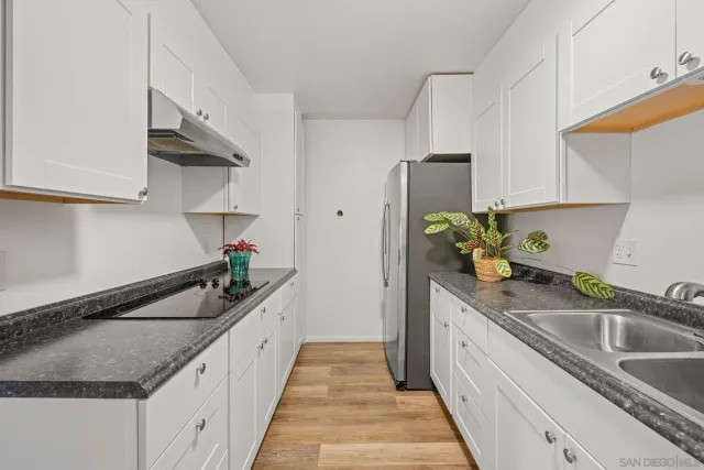 a kitchen with granite countertop a sink and a stove