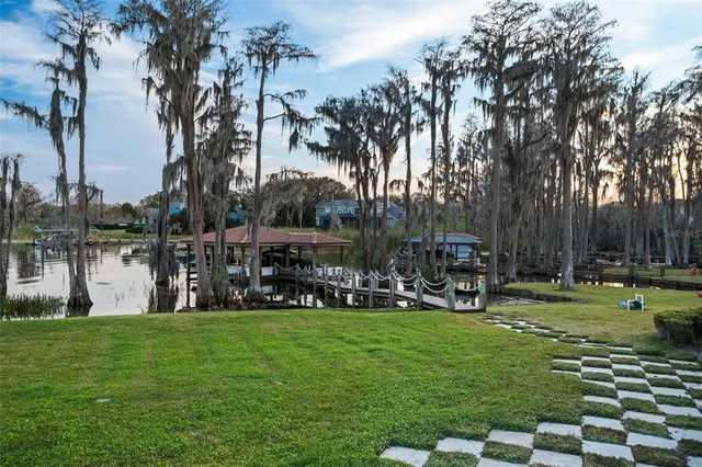 an aerial view of residential houses with outdoor space and lake view
