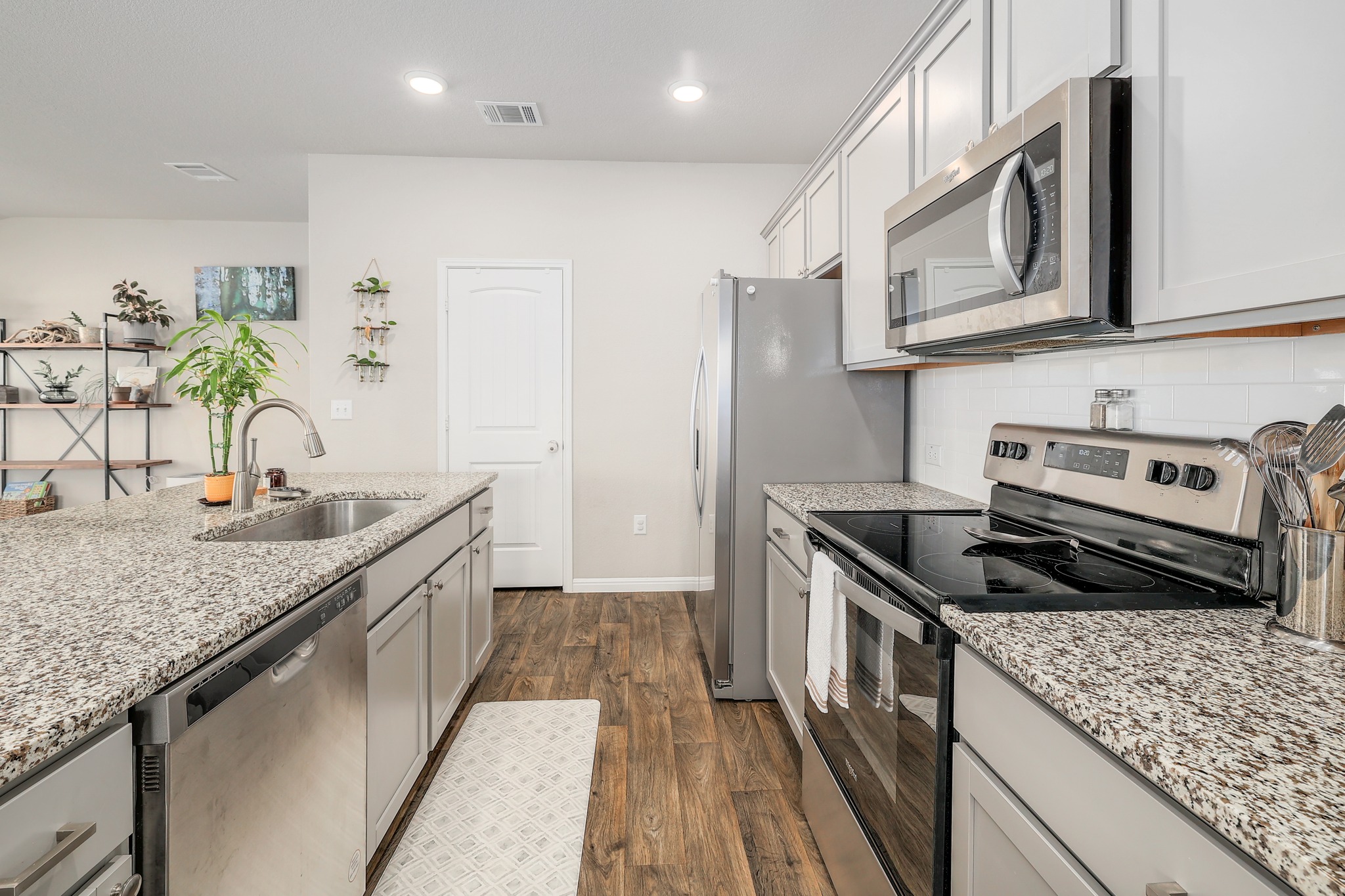 413 Hunter Loop Bertram, TX 78605 - Photo 13 of 27 A pristine culinary space with light cabinetry and granite countertops, perfect for meal preparation.