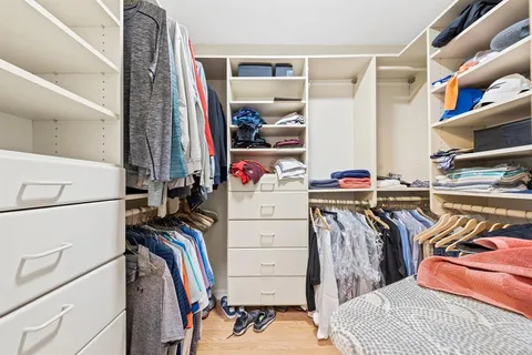 a view of walk in closet with clothes and shoes