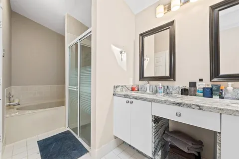 a bathroom with a granite countertop sink mirror and a bathtub
