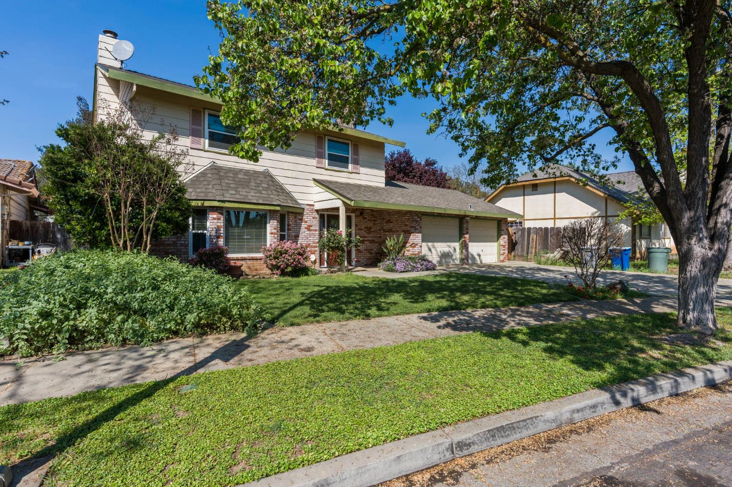 2779 Story Avenue Merced, CA 95340 - Photo 4 of 27 a front view of a house with a garden and trees