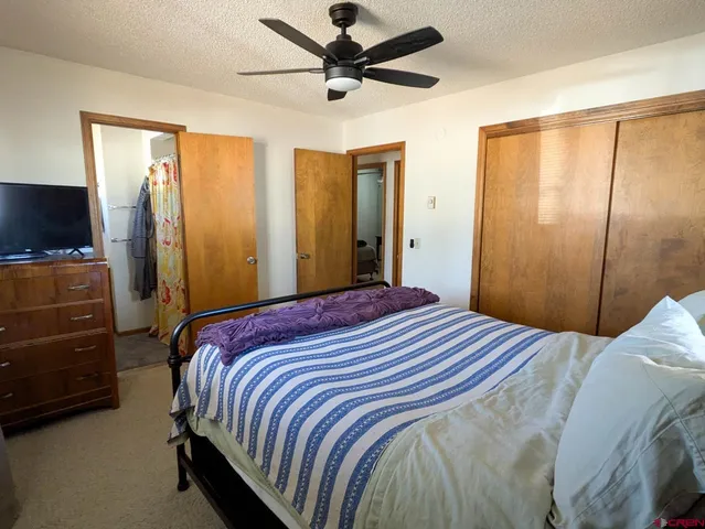 a bedroom with a bed and a flat tv screen