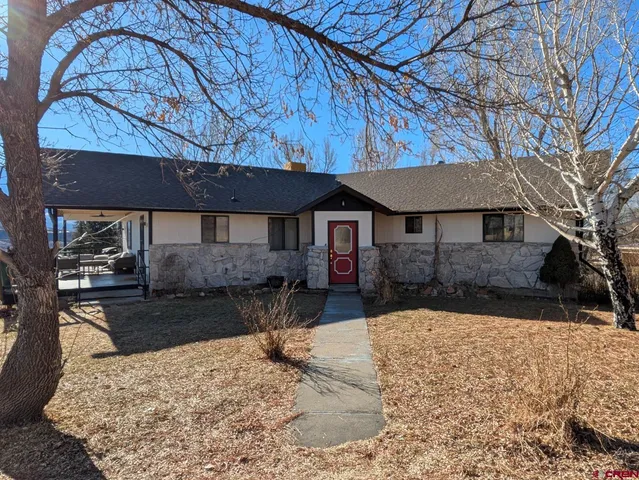 a view of a house with a yard covered in snow