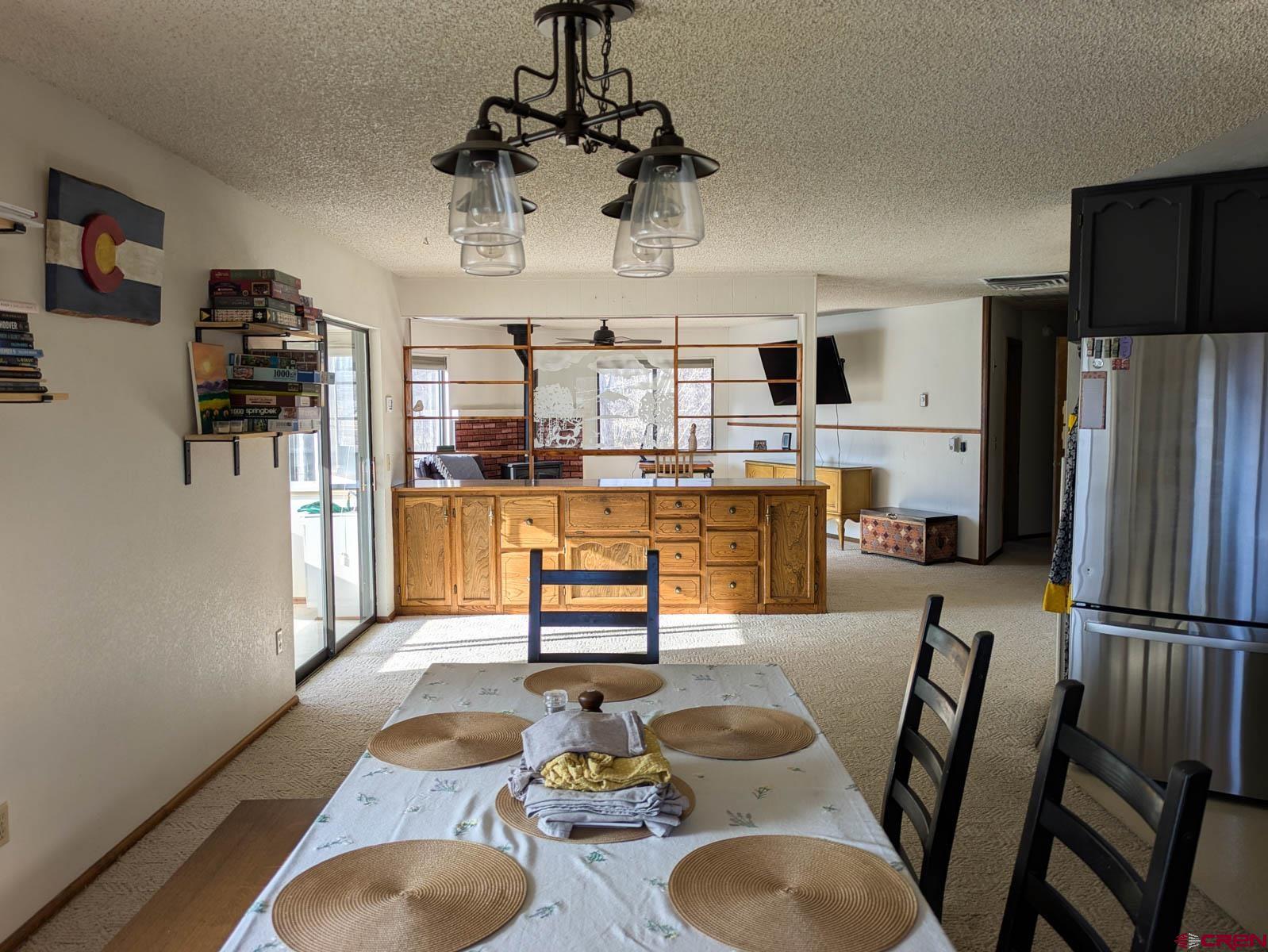 39594 Pitkin Road Paonia, CO 81428 - Photo 8 of 35 a kitchen with stainless steel appliances granite countertop a sink dishwasher a refrigerator and a dining table with wooden floor