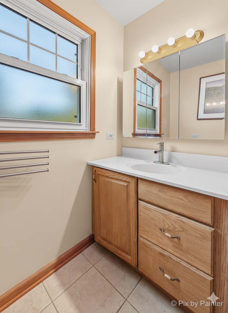 31 West Harrison Road Lombard, IL 60148 - Photo 16 of 31 a bathroom with a sink a mirror and vanity