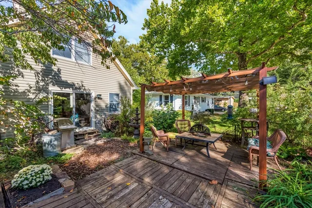 a view of a patio with table and chairs potted plants and large tree