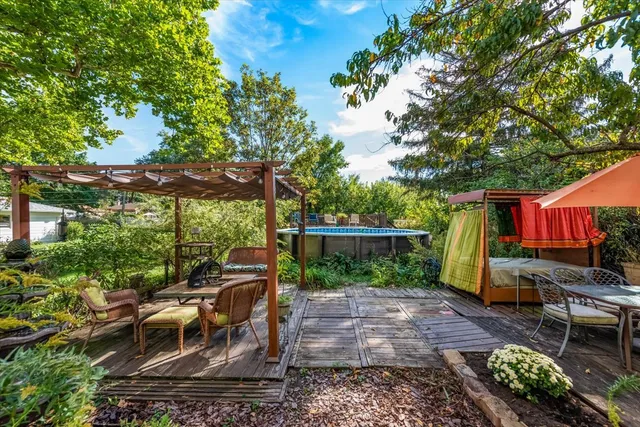 a view of a patio with table and chairs potted plants and large tree