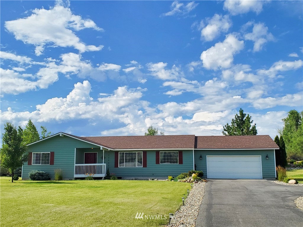 a front view of house with yard and trees around