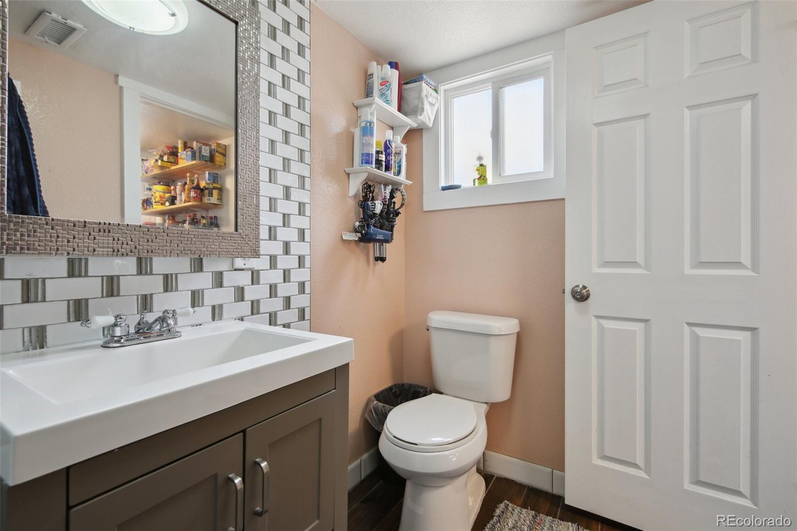 950 South Wolff Street Denver, CO 80219 - Photo 18 of 39 a bathroom with a toilet sink and mirror