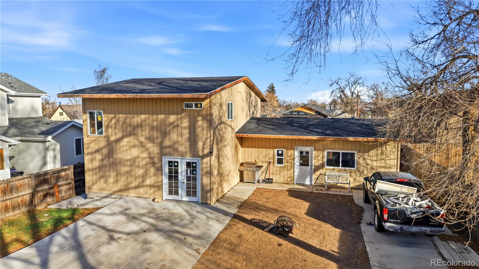 950 South Wolff Street Denver, CO 80219 - Photo 20 of 39 a view of a patio with table and chairs under an umbrella with a large tree