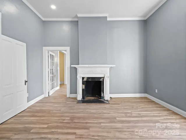a view of empty room with wooden floor and fireplace