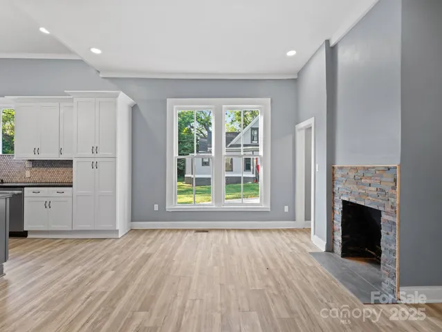 a view of empty room with wooden floor and fireplace