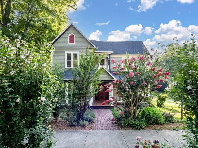 a front view of a house with a yard and garden