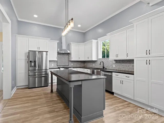 a kitchen with stainless steel appliances granite countertop a sink stove and refrigerator