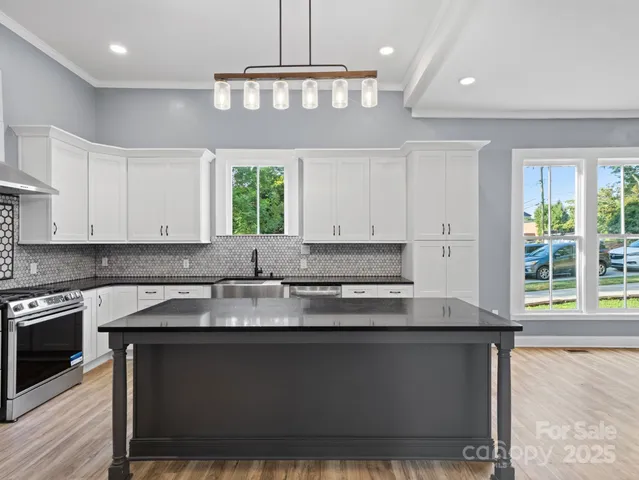 a kitchen with granite countertop a stove a sink and a granite counter top oven