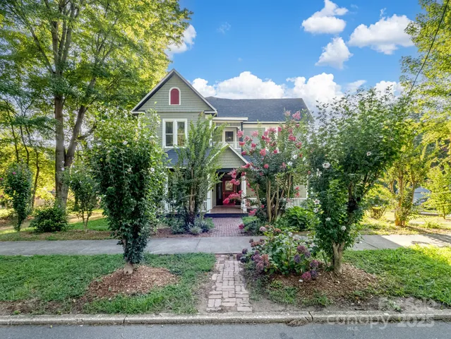 a view of a house with a small yard and wooden floor and fence