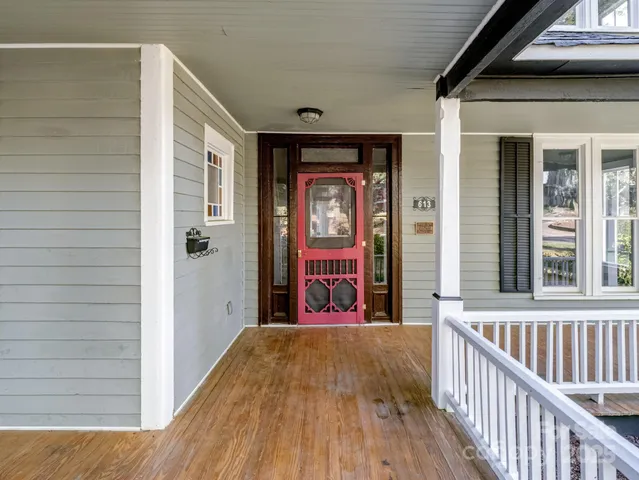 a view of a big room with wooden floor and windows