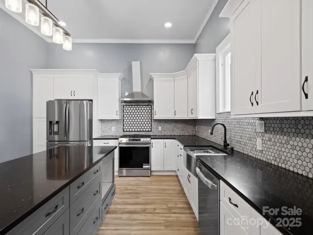 a kitchen with granite countertop a sink a counter space stainless steel appliances and cabinets