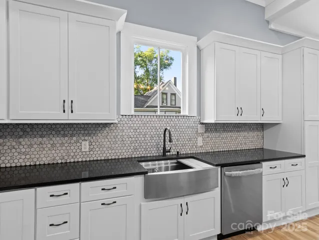 a kitchen with granite countertop white cabinets white appliances and a sink