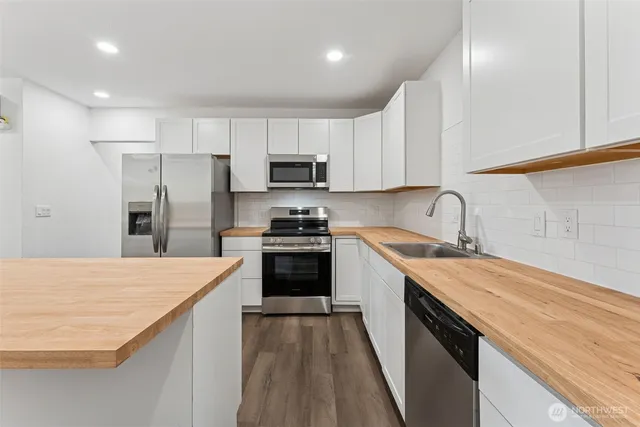 a kitchen with kitchen island a sink stainless steel appliances and cabinets