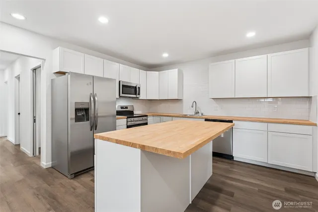 a kitchen with stainless steel appliances granite countertop a refrigerator sink and cabinets