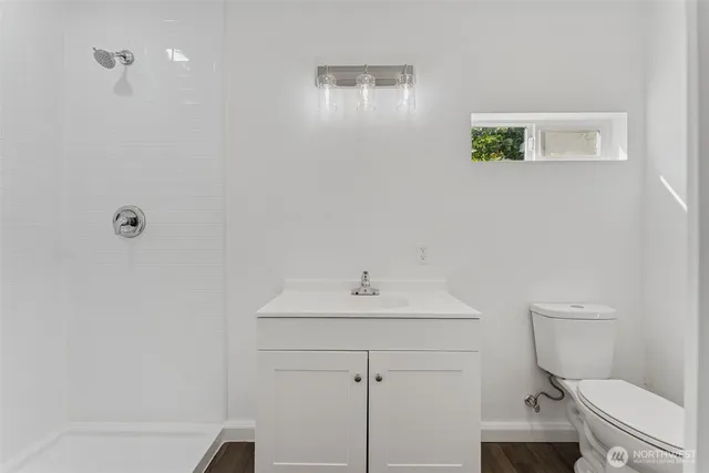 a bathroom with a toilet a sink and mirror