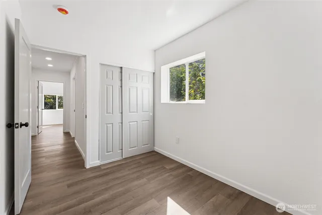 a view of a hallway with wooden floor and closet