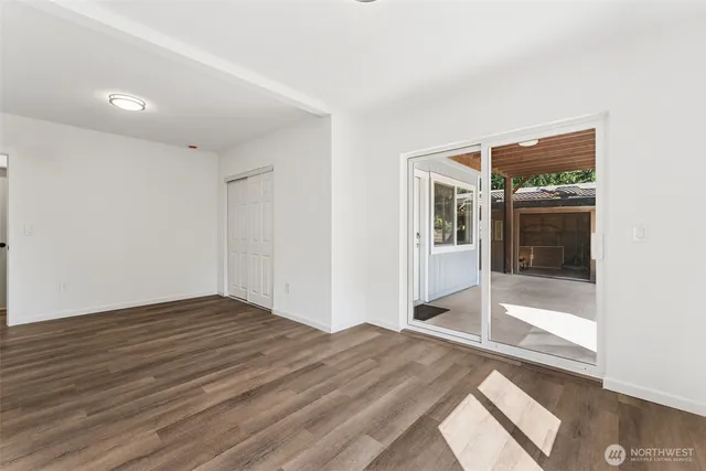 a view of a big room with wooden floor and windows