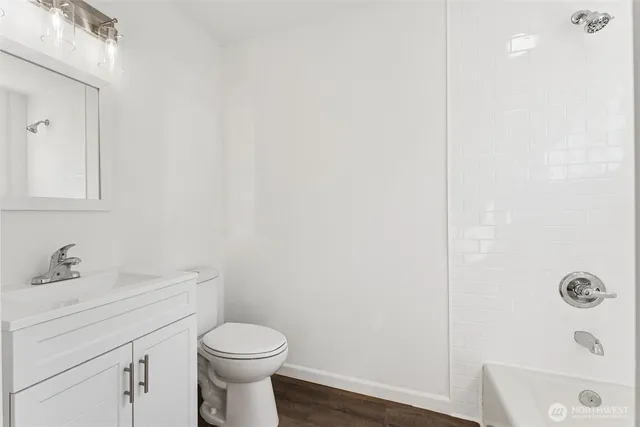 a bathroom with a toilet sink vanity and mirror