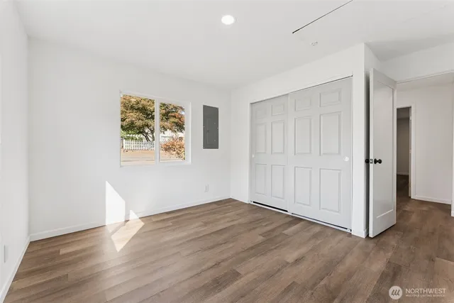 an empty room with wooden floor and window