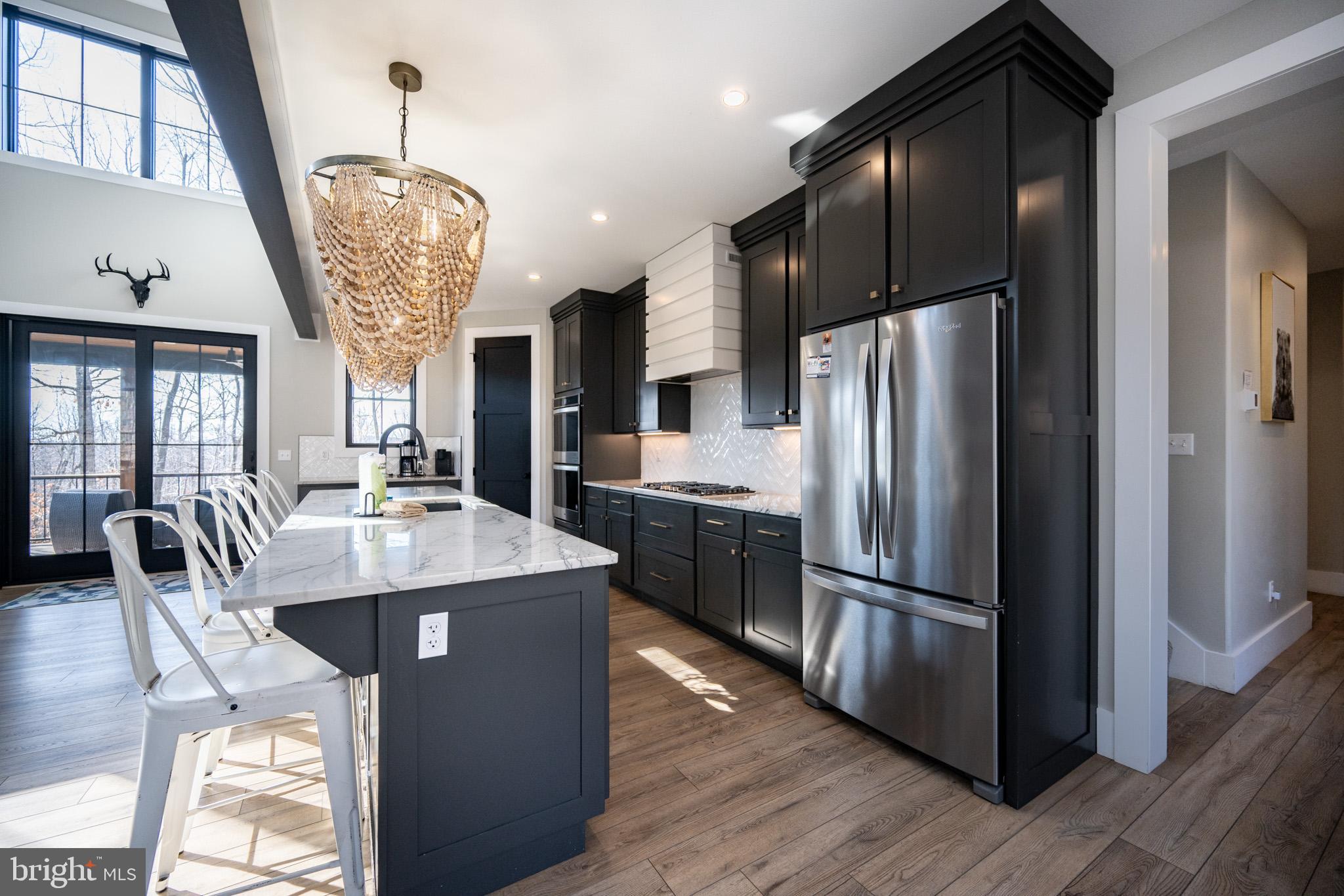 415 Mountaintop Road McHenry, MD 21541 - Photo 30 of 134 a kitchen with stainless steel appliances granite countertop a refrigerator a stove a sink dishwasher a refrigerator and a dining table with wooden floor