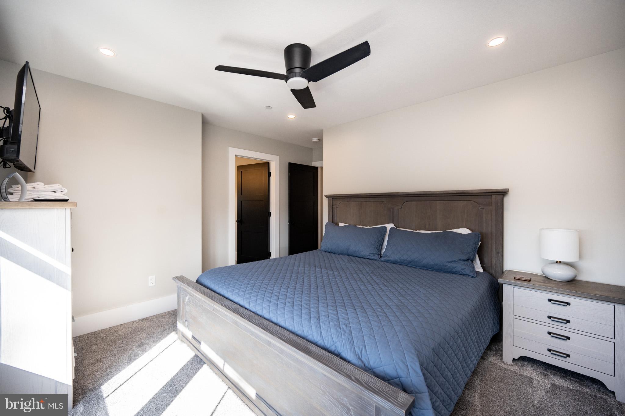 415 Mountaintop Road McHenry, MD 21541 - Photo 62 of 134 a bedroom with a large bed and a chandelier