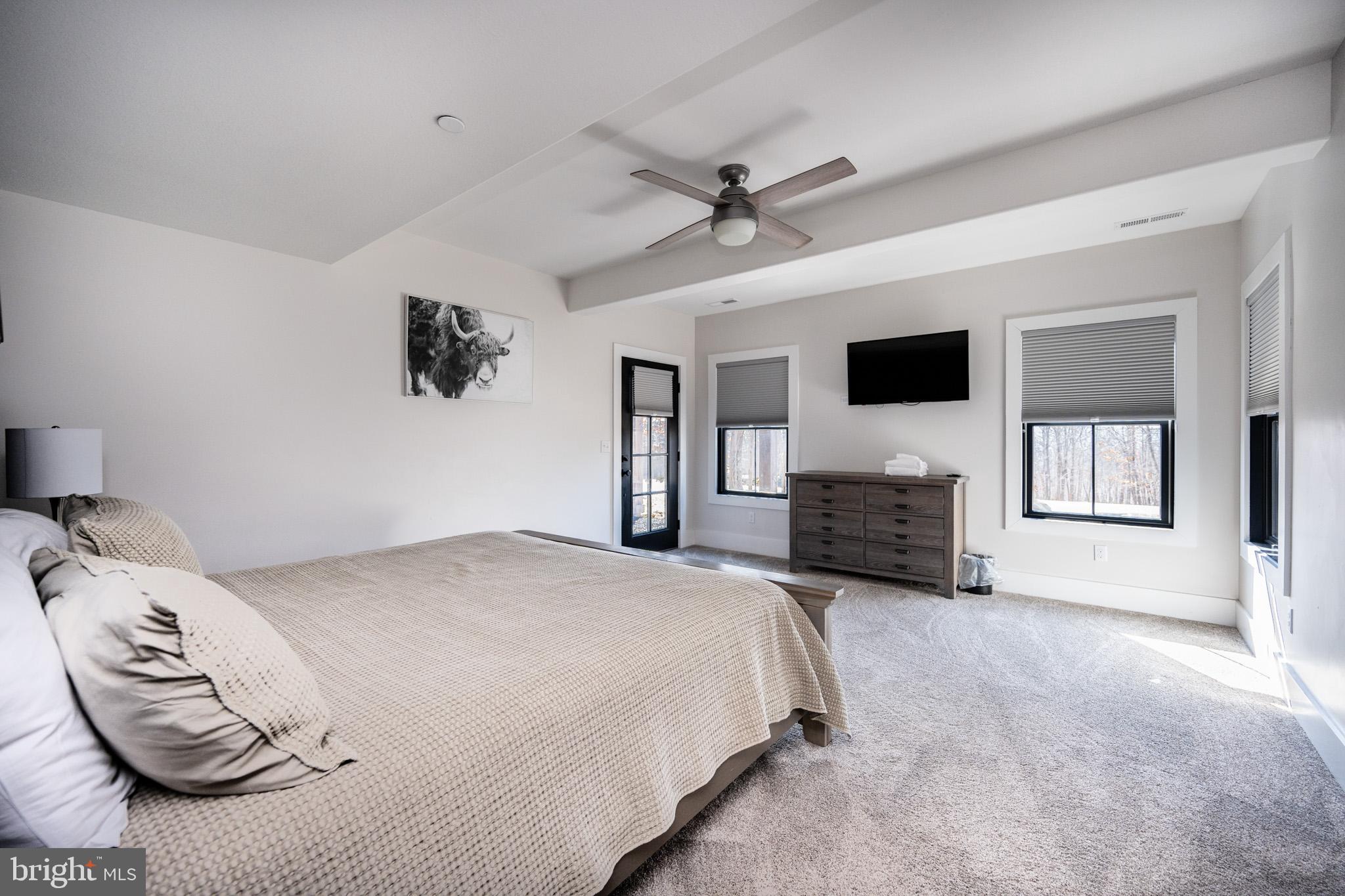 415 Mountaintop Road McHenry, MD 21541 - Photo 76 of 134 a spacious bedroom with a bed a window and a flat screen tv
