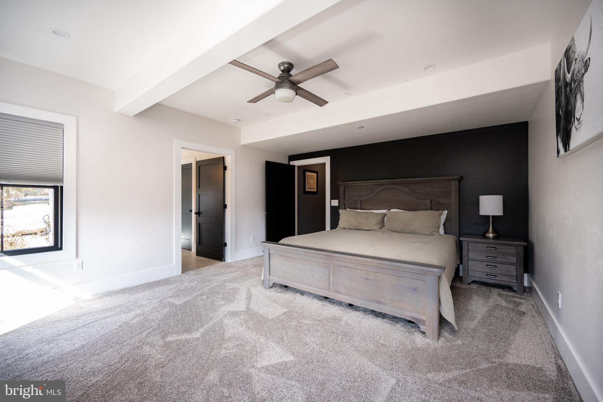 415 Mountaintop Road McHenry, MD 21541 - Photo 78 of 134 a spacious bedroom with a large bed and a chandelier