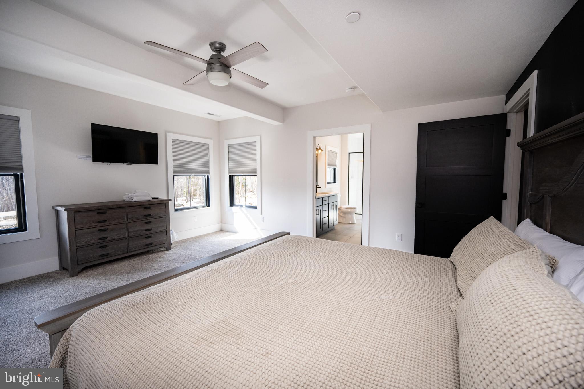 415 Mountaintop Road McHenry, MD 21541 - Photo 79 of 134 a spacious bedroom with a bed a dresser and a flat screen tv