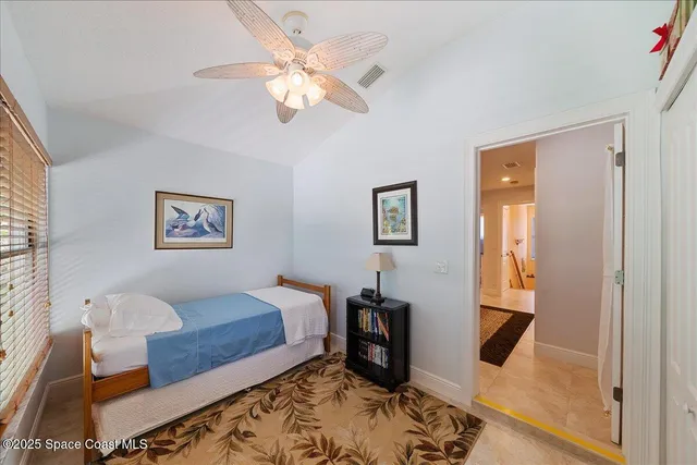 a spacious bedroom with a bed a table and chair