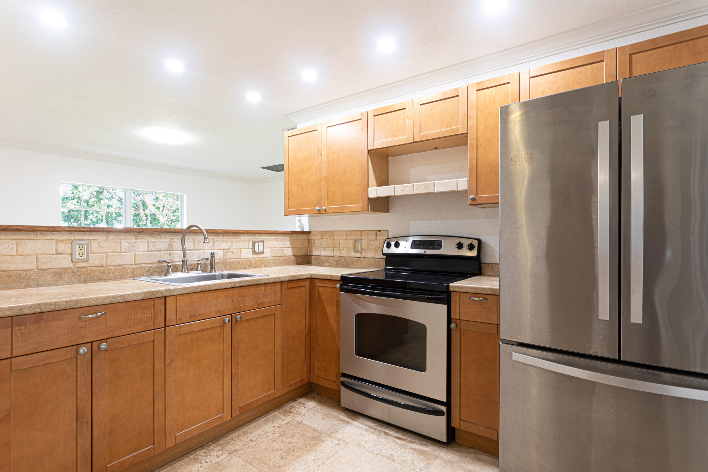 4661 Poseidon Place Lake Worth, FL 33463 - Photo 30 of 36 a kitchen with stainless steel appliances granite countertop a stove a sink and a refrigerator