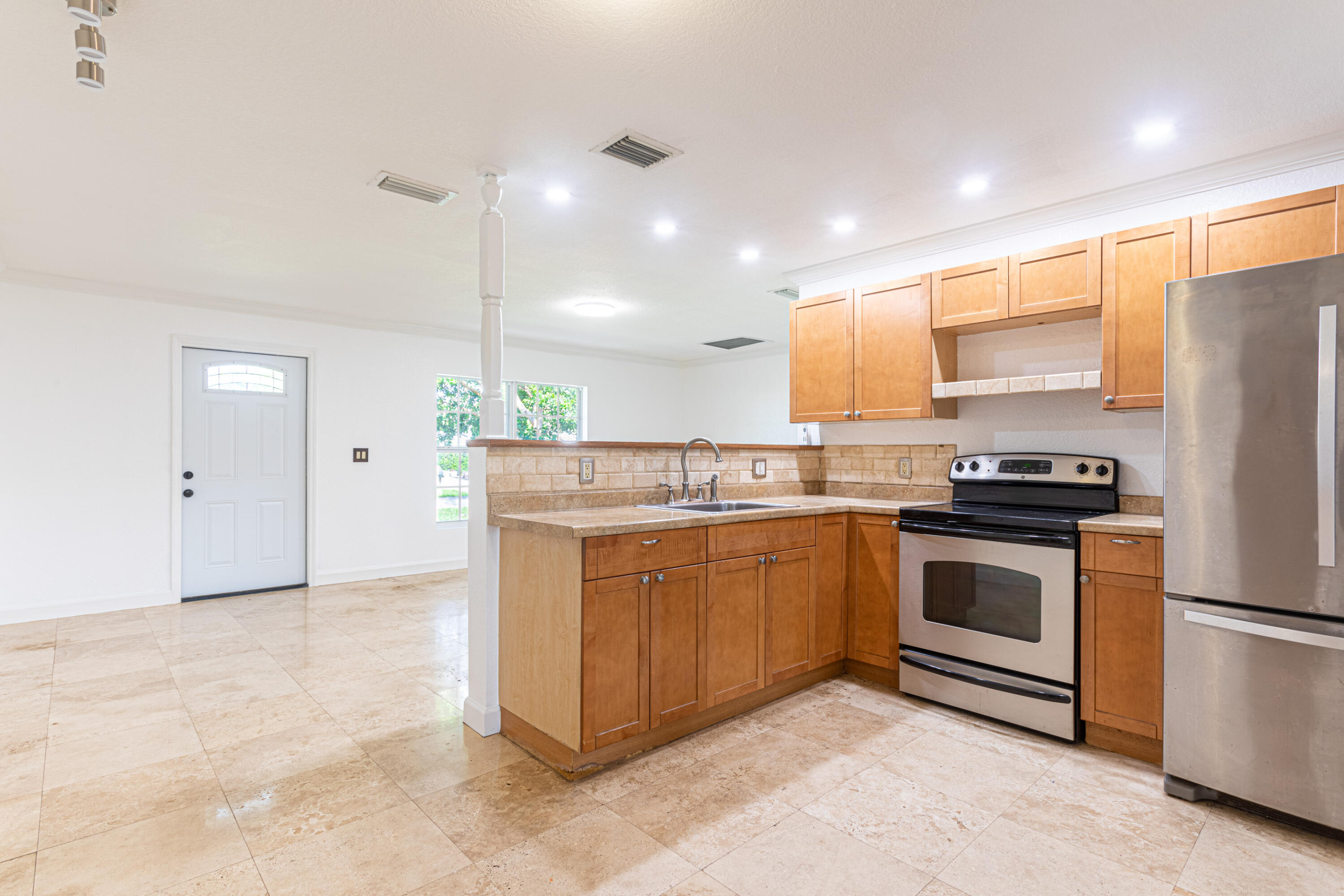4661 Poseidon Place Lake Worth, FL 33463 - Photo 32 of 36 a kitchen with stainless steel appliances granite countertop a stove a sink and a refrigerator