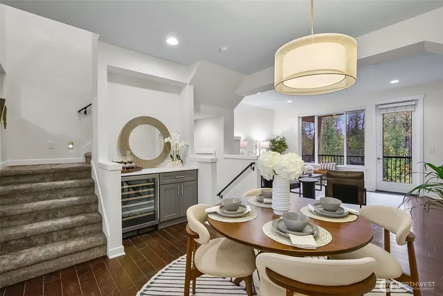 a dining room with wooden floor a chandelier a wooden table and chairs