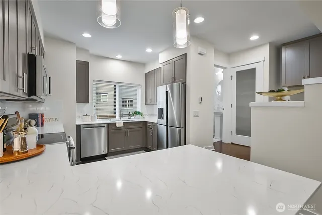 a large kitchen with stainless steel appliances kitchen island a refrigerator sink and cabinets