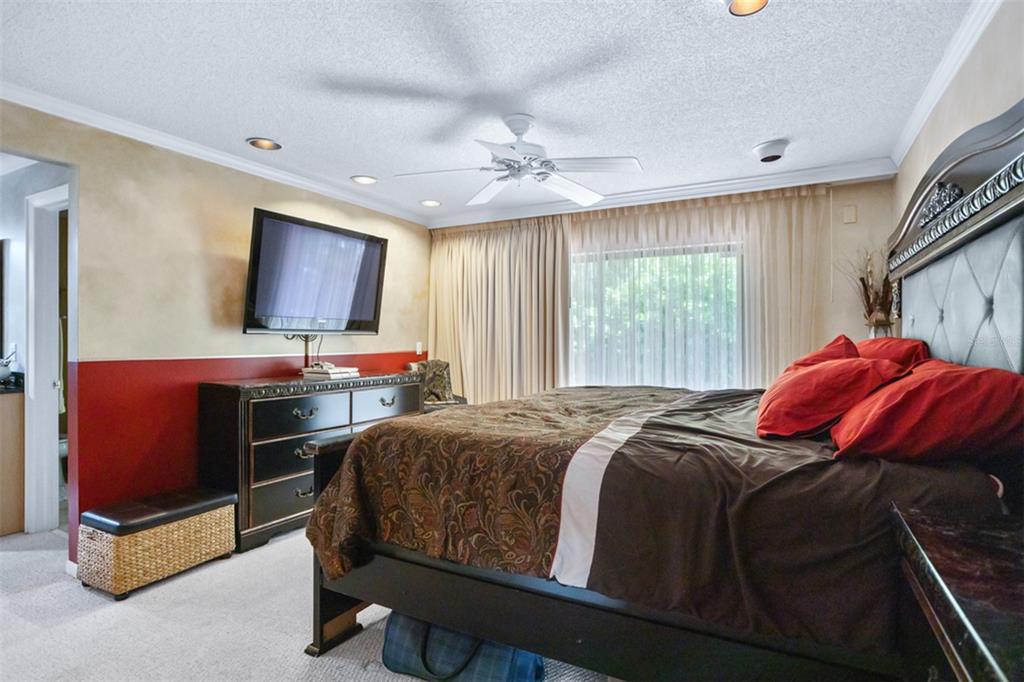 11407 Orilla Del Rio Place Temple Terrace, FL 33617 - Photo 11 of 39 a bedroom with a bed and a flat screen tv