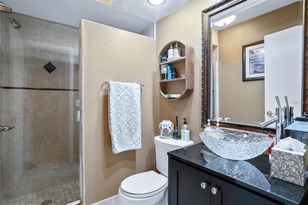 11407 Orilla Del Rio Place Temple Terrace, FL 33617 - Photo 18 of 39 a bathroom with a granite countertop sink a toilet and shower