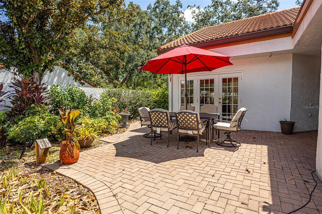 11407 Orilla Del Rio Place Temple Terrace, FL 33617 - Photo 22 of 39 a view of a patio with a table and chairs under an umbrella