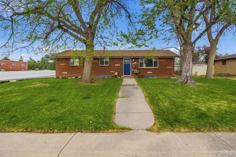 a front view of a house with a yard and trees