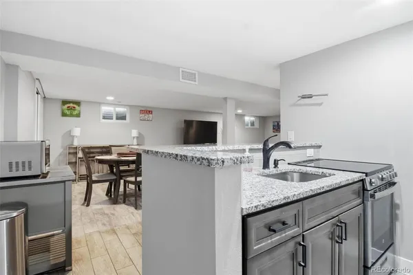 a kitchen with stainless steel appliances granite countertop a sink and a refrigerator