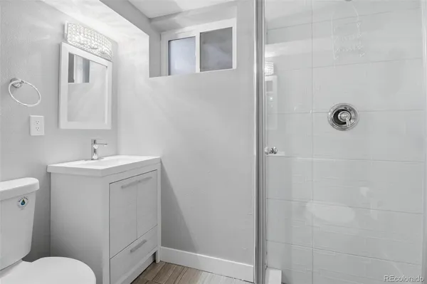a bathroom with a sink a toilet and shower