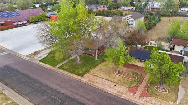 an aerial view of a house with a yard and tennis court