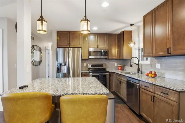 a kitchen with stainless steel appliances granite countertop sink refrigerator and microwave