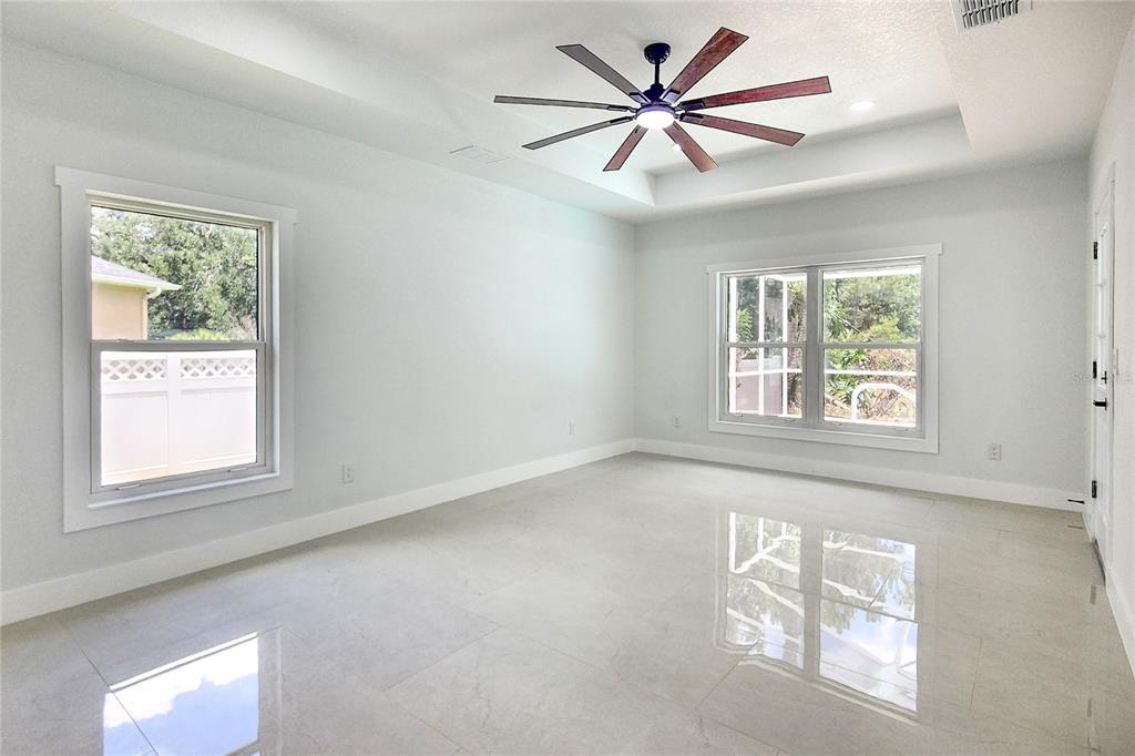 7027 Frascati Loop Wesley Chapel, FL 33544 - Photo 13 of 28 an empty room with windows and fan